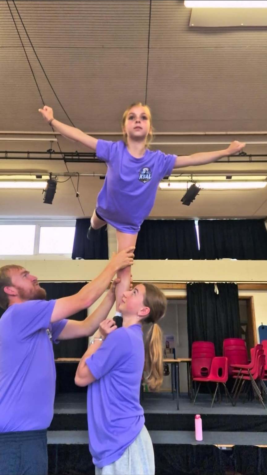 KSAL Athletics team lifting a flyer during a stunt