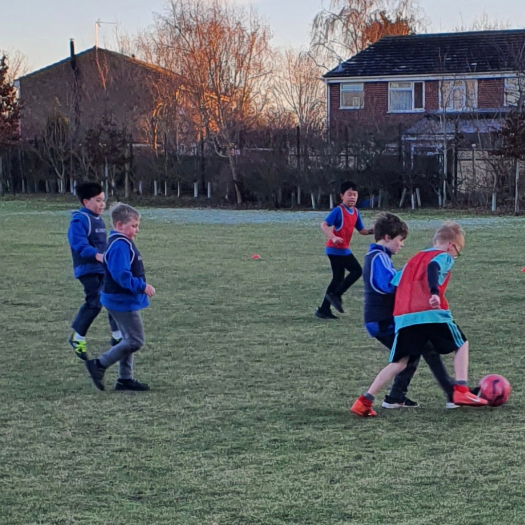 Children playing football at a KSAL session at Girton Glebe Primary School